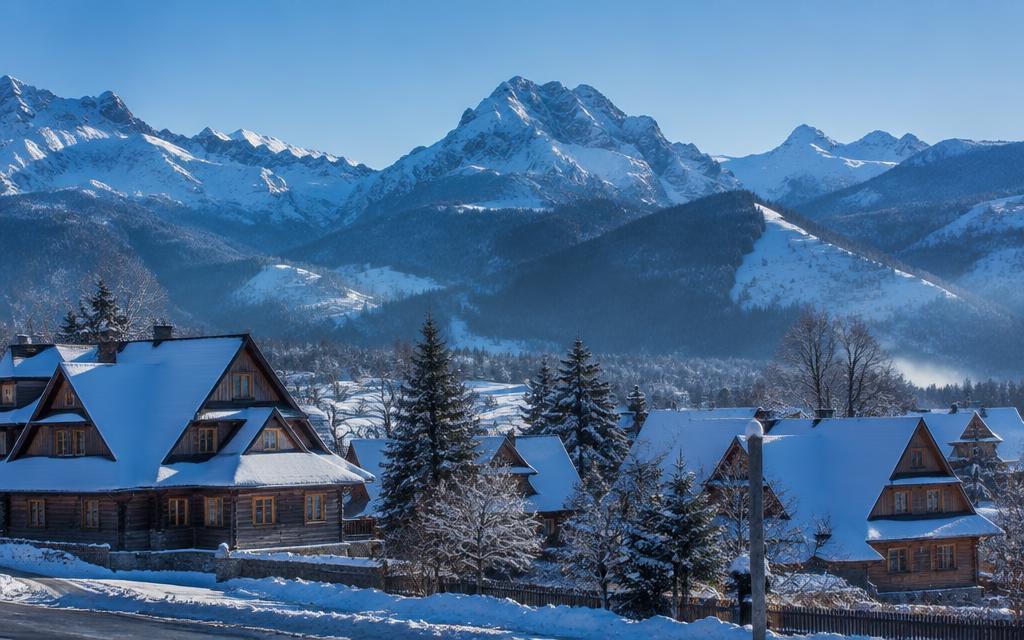 Snowy Tatra mountains above wooden chalets in Zakopane